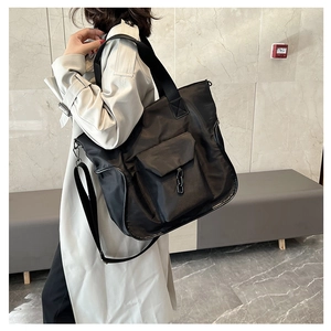 Detailed view of black waterproof nylon tote bag with metal chain and front pocket