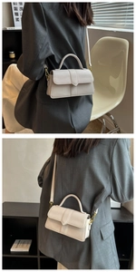 Detail of a creamy leather crossbody bag with gold hardware and top handle for women