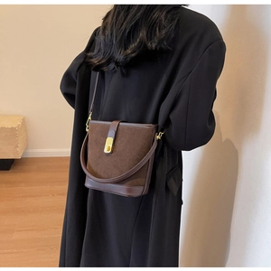 Detail of vintage dark brown matte bucket bag featuring suede leather and gold buckle