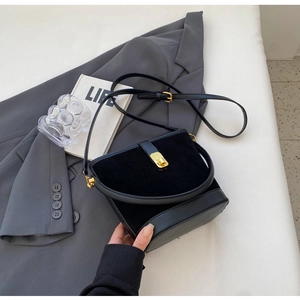 Detail of black vintage bucket bag featuring suede leather and gold metal buckle