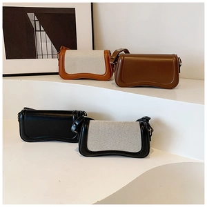 Detail view of stylish underarm bags with wave-shaped bottoms and adjustable straps