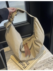 Large beige nylon crescent dumpling bag with wide adjustable strap and dual zippers