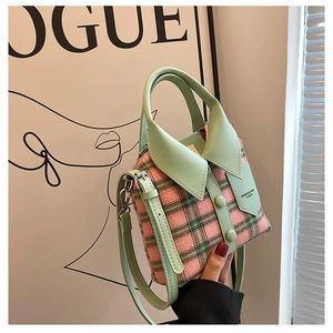 Detailopname van de roze en groen geruite mini handtas met hemdkraag en schouderriem
