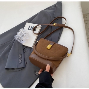 Detail of vintage brown bucket bag showing suede texture and golden metal twist lock