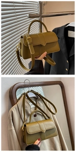 Detail of olive green leather crossbody bag with top handle and adjustable strap