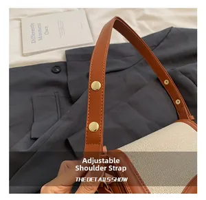 Detailed close-up of adjustable leather shoulder strap with golden buckle on a vintage bag