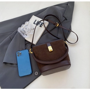 Detail of vintage brown bucket bag showing suede stitching and gold metal buckle