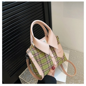 Detail van groen geruite handtas in overhemdstijl met roze kraag en decoratieve knoop