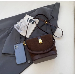 Detail of vintage bucket bag featuring suede texture and gold square metal clasp hardware