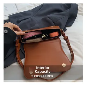 Detail view of brown matte leather shoulder bag showing spacious interior with daily items