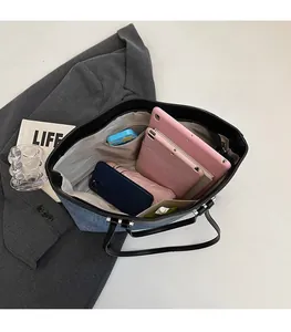 Detail view of denim tote bag showing spacious interior with pockets and daily essentials
