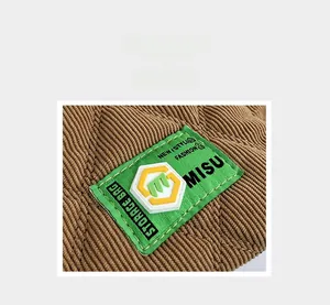 Detailed macro view of the brown corduroy storage bag with a green logo label
