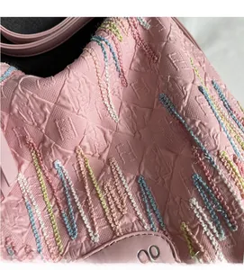 Macro shot of pink jacquard fabric with embossed patterns and colorful knit details