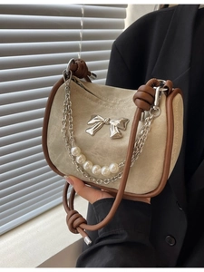 Beige shoulder bag with pearl chain straps and a metal bow, vintage style for women