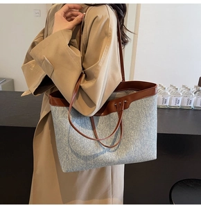 Lifestyle shot of large denim tote bag with brown leather handles and canvas trim