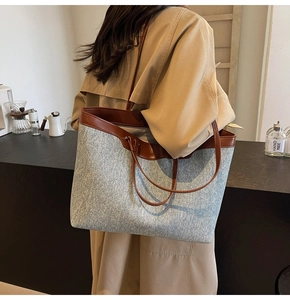 Lifestyle view of large denim tote bag with brown leather straps and spacious interior