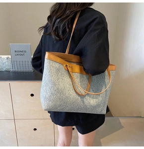 Detail of grey fabric tote bag with brown leather handles and spacious interior layout