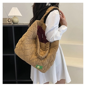 Détail du sac cabas en velours côtelé marron avec matelassage et bandoulière froncée