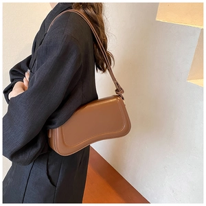 Side view of dark brown leather underarm bag with minimalist curved silhouette