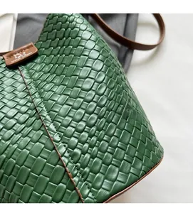 Detailed view of green woven leather bag with soft texture and premium brown leather trim