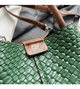 Detailed close-up of dark green woven leather texture and brown buckle with logo