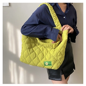 Détail d'un sac cabas en velours côtelé vert fluo avec matelassage et bandoulière plissée