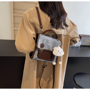 Detalle de mini mochila vintage con colgante de nube y correas de cuero marrón