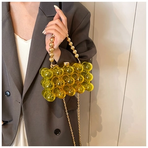 Detail of lime green acrylic bubble bag with golden beaded handle and chain strap