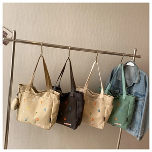 Detail view of multi-pocket canvas tote bags with embroidery and small coin purses