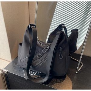 Detailed mirror view of black nylon crescent bag with multiple diagonal zippers