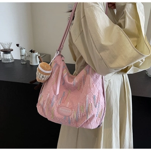 Pink quilted shoulder bag with wave embroidery and a cute plush toy charm detail