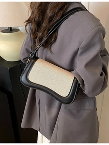 Retro canvas underarm bag with black leather trim shown on a model from back view