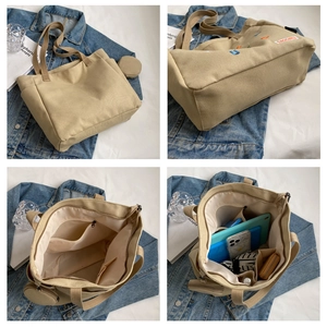 Detailed view of khaki canvas tote bag featuring embroidered letters and round coin pouch