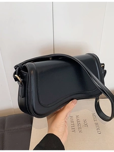 Minimalist black leather underarm bag with gold buckle and adjustable strap for women