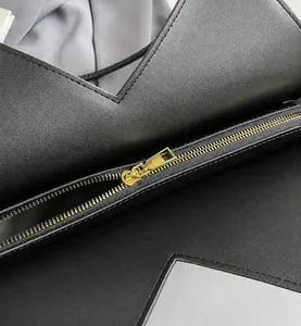 Vue rapprochée de la fermeture éclair dorée et du cuir synthétique grainé noir du sac