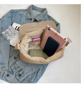 Vue détaillée de l'intérieur spacieux d'un sac bandoulière matelassé beige pour tablette