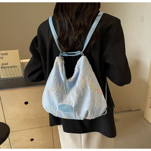 Detail of light blue jacquard fabric backpack with colorful embroidery and HAMIROO logo