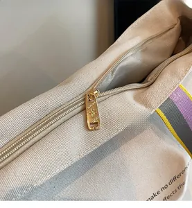 Detailed macro view of high-quality gold metal zipper and canvas texture on tote bag