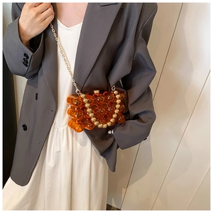Chic orange bubble texture mini bag with gold bead handle shown on a model outfit