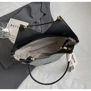 Vue détaillée de la poche zippée interne et de la doublure à chevrons du sac fourre-tout en jean
