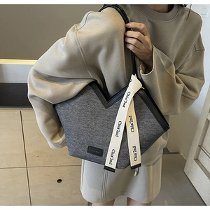 Détail du sac cabas en feutre gris avec bordure cuir en V et ruban décoratif