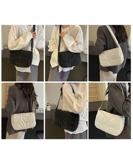 Sac bandoulière matelassé en noir et beige porté dans différents styles de mode
