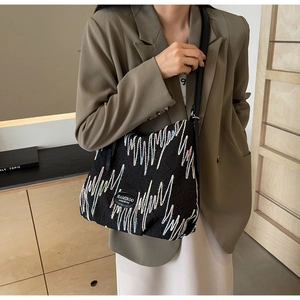 Detail of black tote bag with colorful embroidery and Hamiroo leather patch