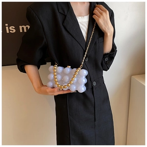 Detail of white translucent bubble-textured mini box bag with gold beaded metal chain
