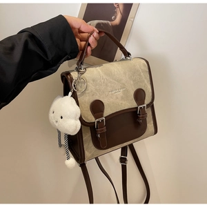 Detalle de mochila vintage de lona y cuero con hebillas dobles y colgante de nube