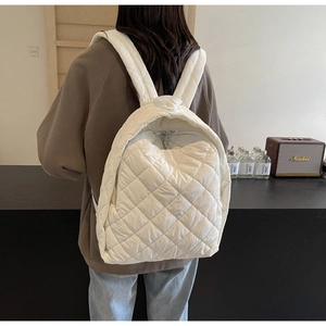 Detaillierte Rückansicht eines weißen gesteppten Puffer-Rucksacks an einem Model