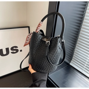 Detail of black woven bucket bag with elegant silk scarf and silver metal buckle