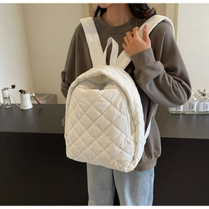 Nahaufnahme eines weißen gesteppten Rucksacks mit Rautenmuster im Café-Stil
