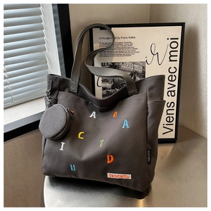 Detail of dark grey canvas tote with colorful letters and small round coin purse
