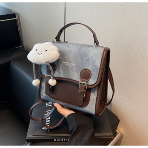 Detalle de mochila vintage de mezclilla con ribete de cuero y un colgante de nube suave